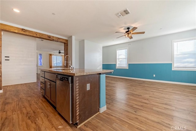 kitchen featuring light hardwood / wood-style floors, sink, dishwasher, and an island with sink