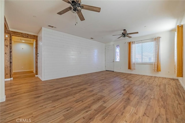 interior space featuring light hardwood / wood-style flooring, ceiling fan, and brick wall