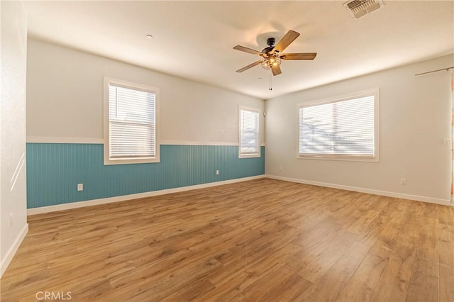 spare room with ceiling fan and light wood-type flooring