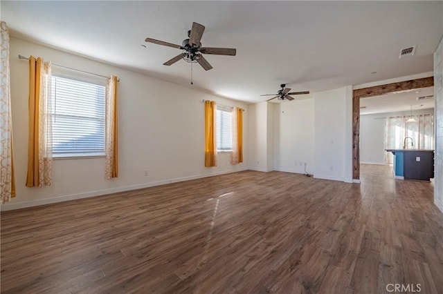 spare room featuring a healthy amount of sunlight and dark hardwood / wood-style floors