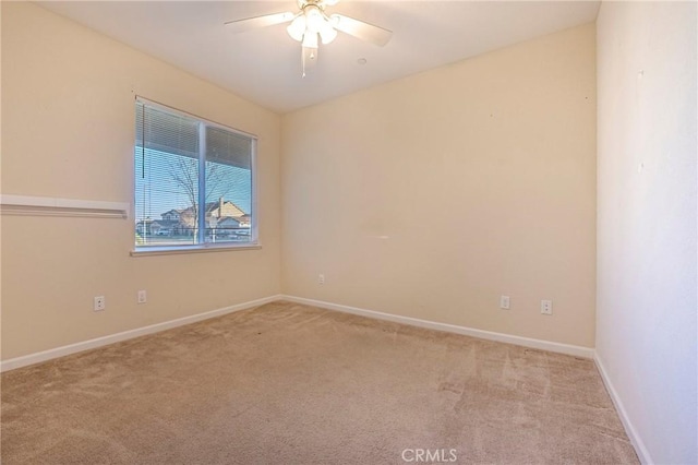 spare room with light colored carpet and ceiling fan