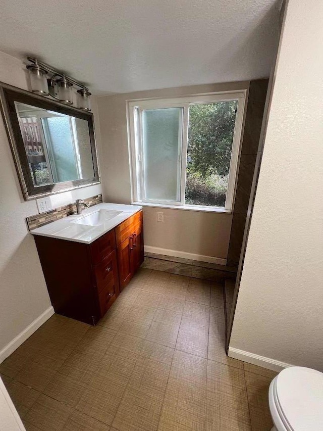 bathroom featuring vanity, a textured ceiling, and toilet