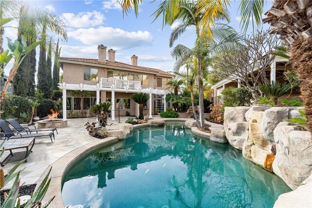 view of pool with a patio, a pergola, and a fire pit