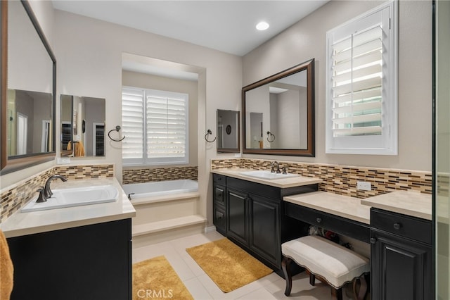 bathroom with vanity, a bathtub, and decorative backsplash