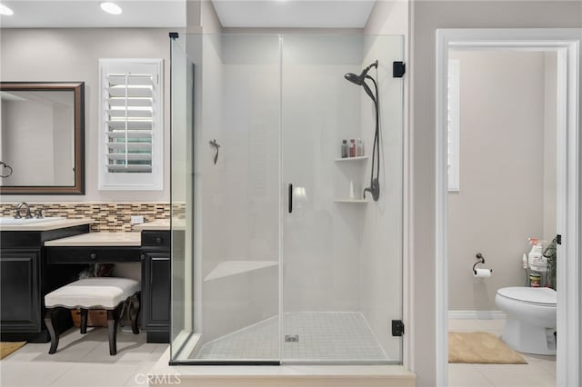 bathroom with toilet, a shower with shower door, vanity, tile patterned flooring, and backsplash