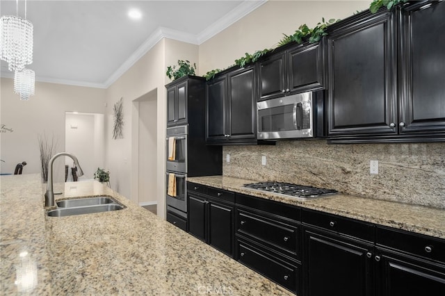 kitchen featuring ornamental molding, stainless steel appliances, sink, and hanging light fixtures