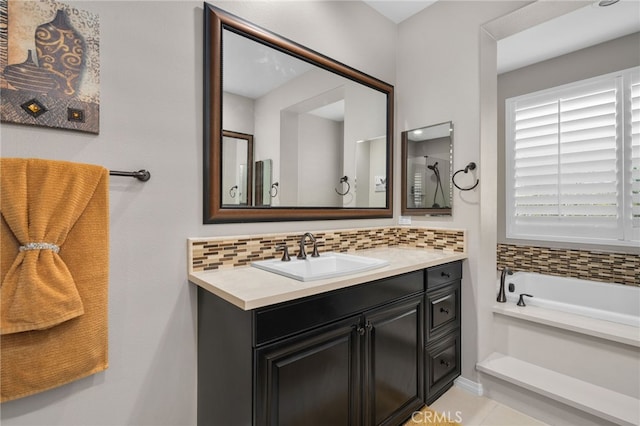 bathroom featuring vanity, a washtub, and decorative backsplash