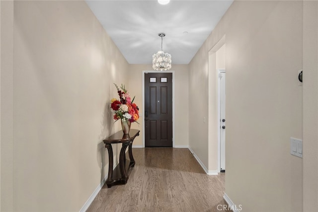 foyer with an inviting chandelier and light hardwood / wood-style flooring