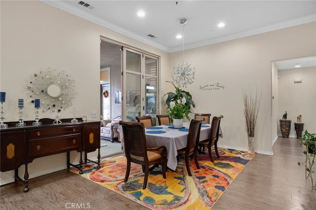 dining area featuring ornamental molding and light hardwood / wood-style flooring