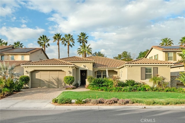 mediterranean / spanish home with a garage and a front yard