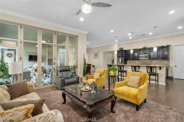 living room with ornamental molding, dark wood-type flooring, and ceiling fan