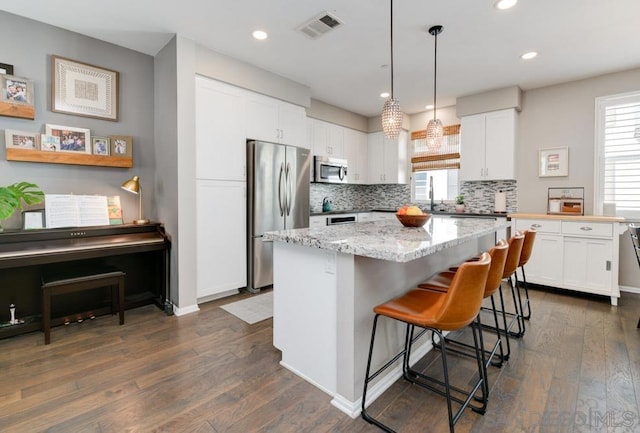 kitchen with stainless steel appliances, a center island, and white cabinets