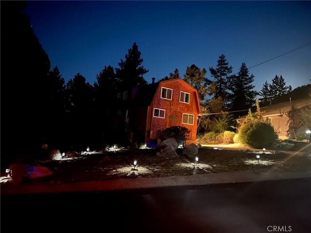 property exterior at night featuring an outbuilding