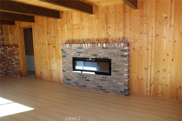 unfurnished living room with beamed ceiling, wood ceiling, wooden walls, and wood-type flooring