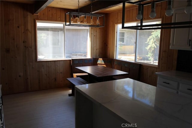 unfurnished dining area with breakfast area, wood ceiling, a healthy amount of sunlight, and beamed ceiling