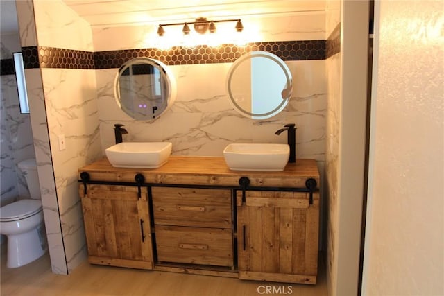 bathroom featuring vanity, toilet, hardwood / wood-style floors, and decorative backsplash