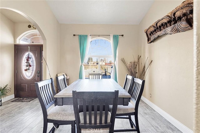 dining space with lofted ceiling and light hardwood / wood-style flooring