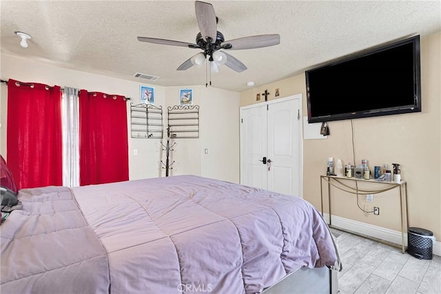 bedroom with ceiling fan and a textured ceiling