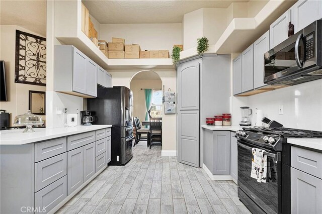 kitchen featuring light hardwood / wood-style flooring, gray cabinets, and appliances with stainless steel finishes