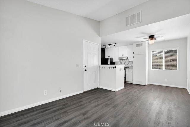 unfurnished living room with dark hardwood / wood-style flooring and ceiling fan