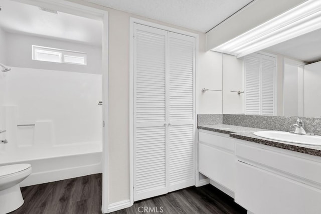 full bathroom with vanity, hardwood / wood-style floors, tub / shower combination, and toilet