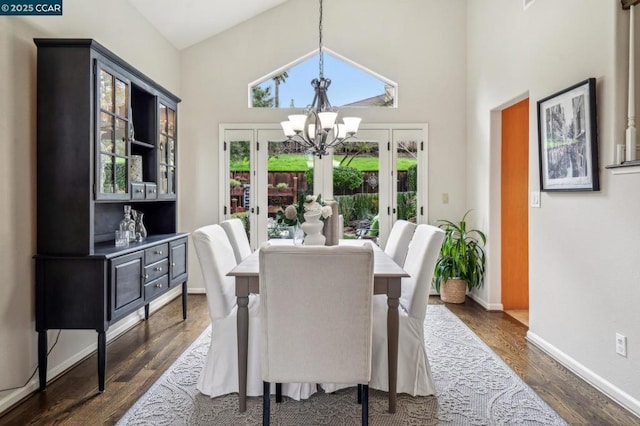 dining room featuring french doors, a towering ceiling, dark hardwood / wood-style floors, and a chandelier