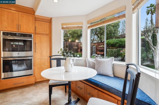 kitchen featuring breakfast area, light tile patterned flooring, and double oven