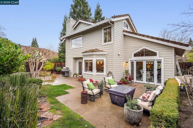 back of house with an outdoor living space, a patio, and french doors