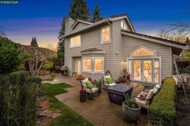 back house at dusk featuring a patio