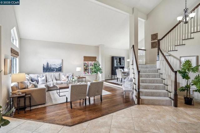 living room with an inviting chandelier, high vaulted ceiling, and light tile patterned flooring