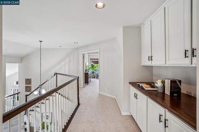 corridor featuring light colored carpet