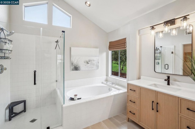 bathroom featuring vaulted ceiling, separate shower and tub, a healthy amount of sunlight, and vanity