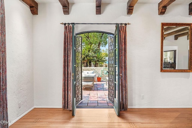 foyer featuring hardwood / wood-style flooring and beamed ceiling