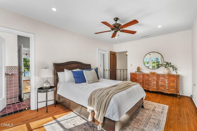 bedroom with hardwood / wood-style flooring, ceiling fan, and multiple windows