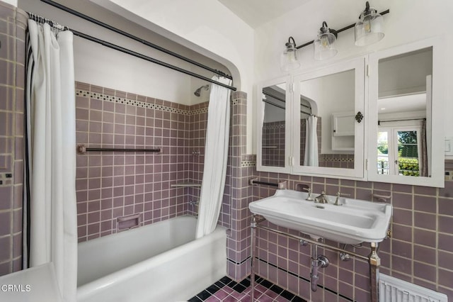 bathroom with tile walls, sink, tile patterned floors, and shower / bath combo with shower curtain