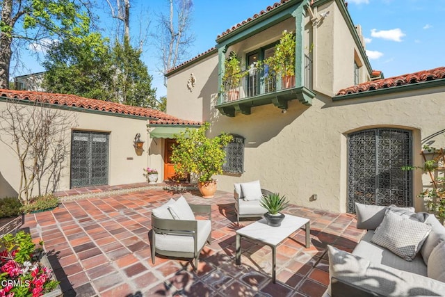 back of house featuring a patio, a balcony, and an outdoor hangout area