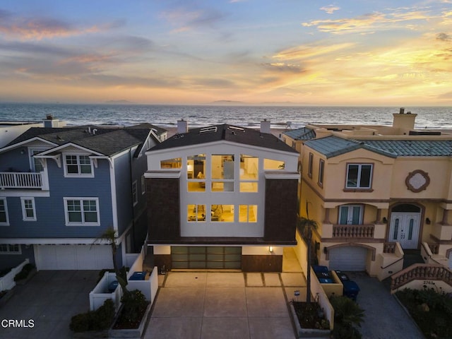 view of front of property featuring a garage and a water view