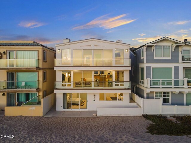 3757 Ocean Dr, Oxnard, CA 93035 - back of property at dusk with a balcony and stucco siding