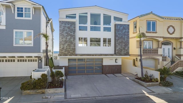 3757 Ocean Dr, Oxnard, CA 93035 - view of front of property with stone siding, a garage, concrete driveway, and stucco siding