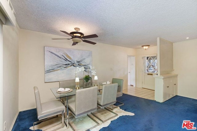 dining room with ceiling fan, carpet, and a textured ceiling