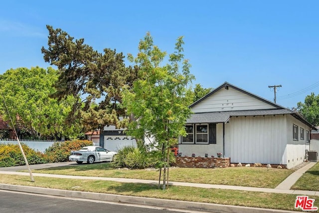 view of front of house featuring a garage, central AC, and a front lawn