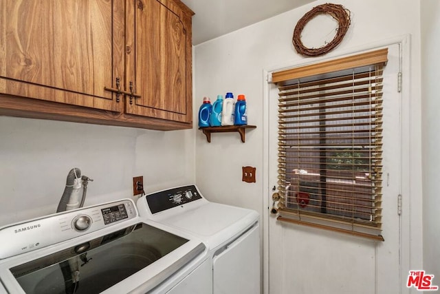 clothes washing area with washing machine and dryer and cabinets