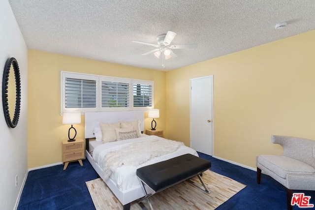 bedroom featuring ceiling fan, a textured ceiling, and dark carpet