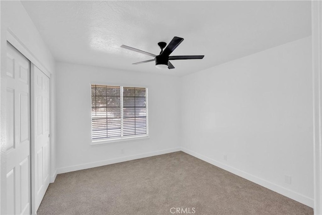 unfurnished bedroom featuring light colored carpet, a closet, and ceiling fan