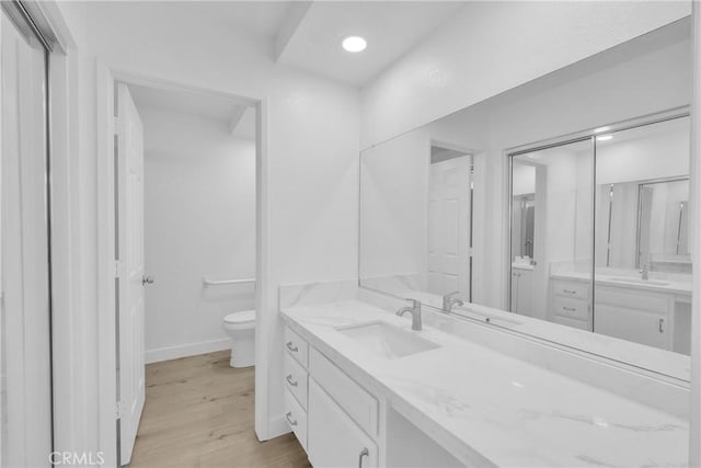 bathroom featuring vanity, hardwood / wood-style floors, and toilet