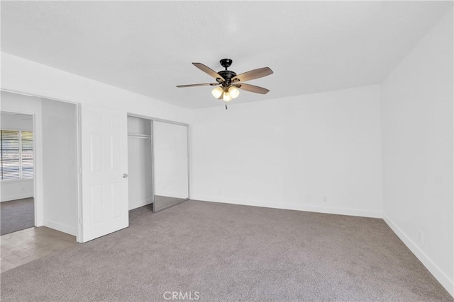 unfurnished bedroom with ceiling fan, carpet flooring, and a closet