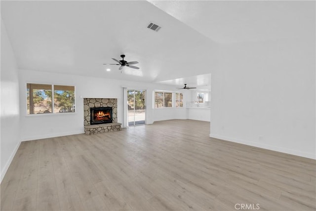 unfurnished living room with light hardwood / wood-style flooring, a fireplace, ceiling fan, and plenty of natural light