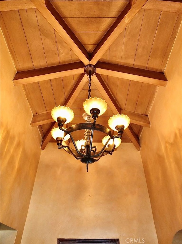 room details with beamed ceiling, a chandelier, and wood ceiling