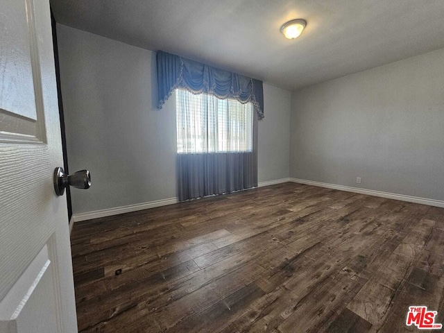 empty room with dark wood-type flooring