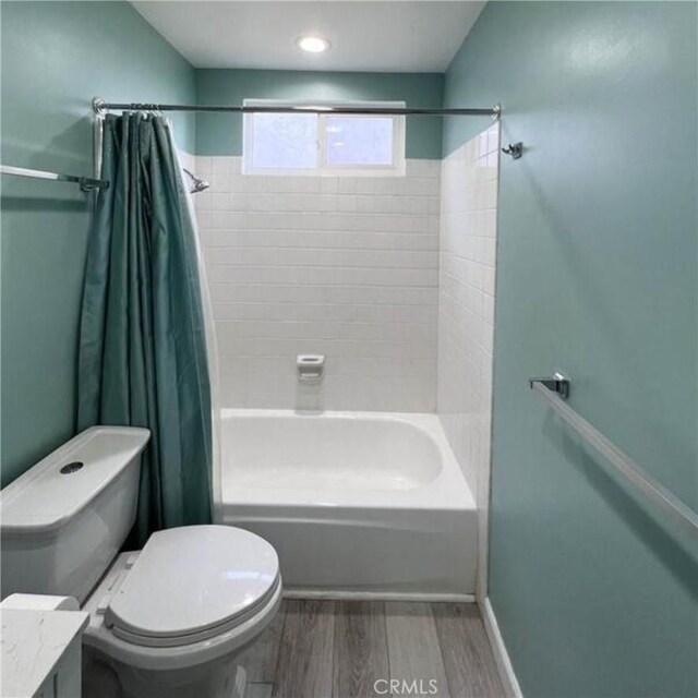 full bathroom with wood-type flooring, toilet, vanity, and shower / bath combo